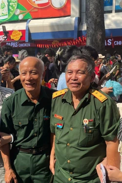 ប្រជាជនរង់ចាំយ៉ាងអ៊ូអរនូវដង្ហែក្បួនរបស់កងកម្លាំង​ធ្វើការផ្លាស់ប្ដូរបន្ទាប់ពីពិធីកិច្ច