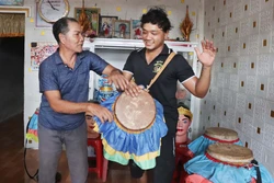 សិប្បករ ថាច់ ទុង បង្រៀនពីរបៀបវាយស្គរឆៃយ៉ាំ ដល់ ថាច់ សែន ជាកូនប្រុសពៅក្នុងគ្រួសារ។