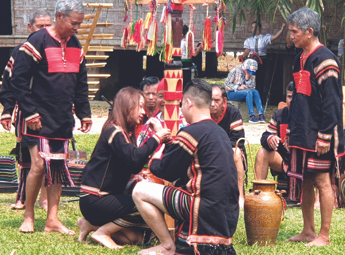 មនុស្សម្នាក់ៗ ក្នុងវង្សត្រកូលអញ្ជើញបំពាក់កងដៃអោយម្ចាស់ផ្ទះដើម្បីផ្ដាំផ្ញើមនោសញ្ចេតនានៃការគោរពស្រឡាញ់ រាប់អានគ្នាទៅវិញទៅមកផ្សារភ្ជាប់ក្នុងសហគមន៍ ពិធីសែនដើម នេវ សុំសេចក្តីសុខរបស់ជនជាតិ អេដេ ảnh 3