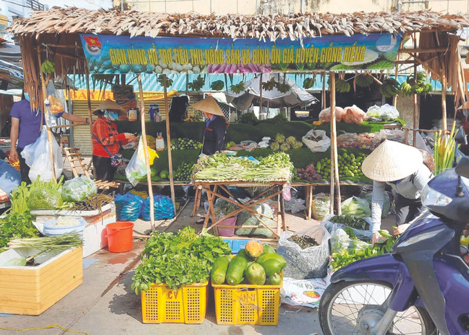 ស្តង់ទំនិញជួយលក់ដូរកសិផលនិងរក្សាលំនឹងតម្លៃទីផ្សារនៅទីរួមស្រុក យ៉ុងរៀង ស្រុក យ៉ុងរៀង (ខេត្ត កៀនយ៉ាង) ការរួមកម្លាំងគ្នា ពុះពារជម្នះជំងឺរាតត្បាតសកលនៅតំបន់បងប្អូនជនជាតិ ខ្មែរ ណាមបូ ảnh 8