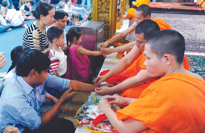 ព្រះសង្ឃចងខ្សែអំបោះក្រហមអោយពុទ្ធបរិស័ទ ខ្មែរ ណាមបូ នាឱកាសបុណ្យចូលឆ្នាំថ្មីប្រពៃណី ពិធីកិច្ច "ចងដៃ" របស់ជនជាតិ ខ្មែរ ណាមបូ ảnh 2