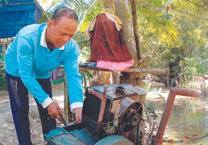 លោក ថាច់ សាខា ពិនិត្យមើលម៉ាស៊ីនបូមទឹកមុនពេលបូមទឹកអោយមាមីងបងប្អូនជនជាតិ ខ្មែរ នៅភូមិលេខ ៩ ឃុំ វីទ្រុង ស្រុក វីធុយ (ខេត្ត ហូវយ៉ាង) លោក ថាច់ សាខា កសិករ ខ្មែរ ម្នាក់អស់ពីចិត្តពីថ្លើមដើម្បីសហគមន៍ ảnh 2