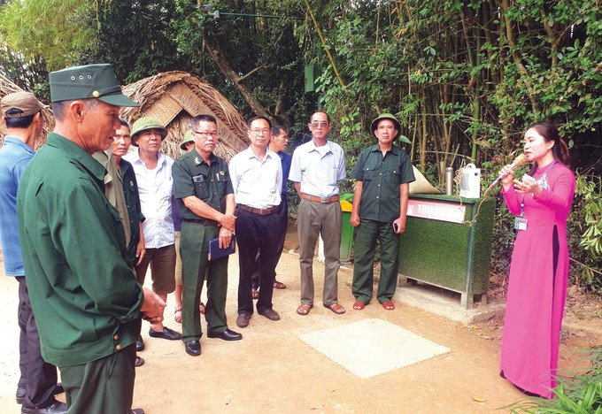 អ្នកអធិប្បាយរៀបរាប់ដំណើររឿងអំពីលោកអ៊ំ ហូ យ៉ាងជក់ចិត្តជូនភ្ញៀវទស្សនាមណ្ឌលកេរដំណែលជាតិពិសេស គីមលៀន នៅឃុំ គីមលៀន (ស្រុក ណាមដាន ខេត្ត ងេអាន) a02.jpg