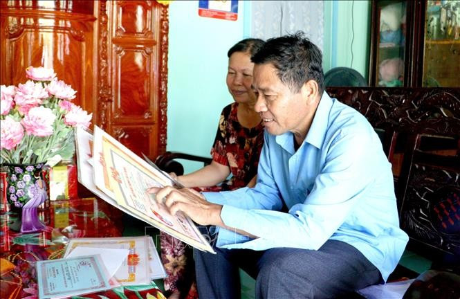 លោក ថាច់លត់ (ឃុំ លាន់មី ស្រុក តាមប៊ិញ ខេត្ត វិញឡុង) ឧទ្ទេសនាមអំពីស្នាដៃសមិទ្ធិផលសិក្សានិងកិច្ចការងាររបស់កូនៗ។ រូបថត៖ ឡេ ធុយហាំង - ទីភ្នាក់ងារព័ត៌មានវៀតណាម 04-potal-suc-song-moi-o-vung-dong-bao-dan-toc-khmer-tinh-vinh-long-stand.jpg