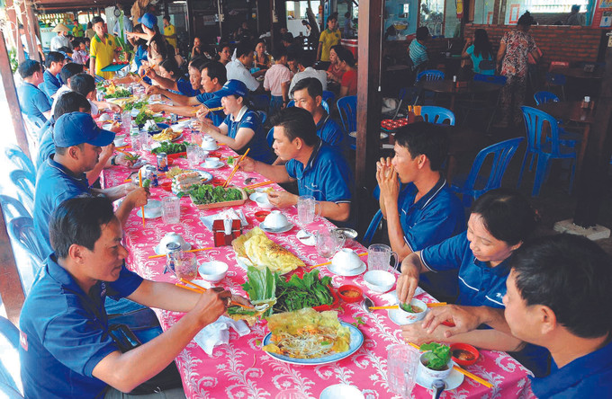 ភ្ញៀវទេសចរពិសានំចាក់អំបែងនៅហាងនំចាក់អំបែង អាម៉ឹត ជាហាងមួយក្នុងចំណោមហាងពិសេសដាច់ដោយឡែកនៅមណ្ឌលទេសចរណ៍ យ៉ុងញ៉ាន នៅឃុំ ហៀបថាញ់ ទីក្រុង បាកលៀវ នំចាក់អំបែង យ៉ុងញ៉ាន ដ៏ទាក់ទាញ ảnh 2