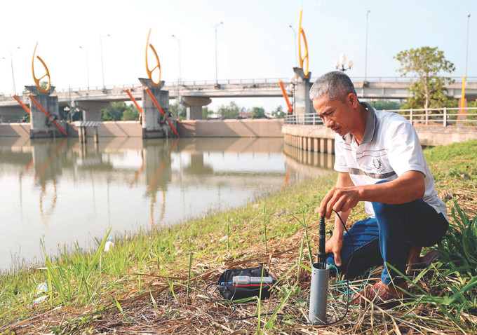 បុគ្គលិកប្រតិបត្តិករទំនប់ បុងបត នៅឃុំ អាន ភូតឹន ស្រុក កូវកែ (ខេត្ត ត្រាវិញ) ប្រចាំការ ២៤/២៤ ម៉ោង វាស់កម្រិតជាតិប្រៃពីរដងក្នុងមួយថ្ងៃ Tra Vinh tim nuoc ngot cho vung han man 4A.JPG
