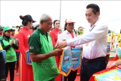 អនុប្រធានគណៈកម្មាធិការប្រជាជនខេត្ត វិញឡុង ប្រគល់ជូនទង់អនុស្សាវរីយ៍ដល់បណ្តាក្រុមចូលរួមការប្រណាំងទូក។ រូបថត៖ ថាញ់ហ្វា​ - ទីភ្នាក់ងារព័ត៌មានវៀតណាម