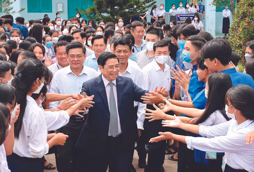 នាយករដ្ឋមន្ត្រីនៃរដ្ឋាភិបាល ផាម មិញជិញ ជាមួយកូនសិស្សវិទ្យាល័យមធ្យមសិក្សាចំណេះទូទៅអន្តេវាសិកជនជាតិ ហ្វ៊ិញកឿង ក្នុងឱកាសដំណើរបេសកកម្មនៅខេត្ត សុកត្រាំង