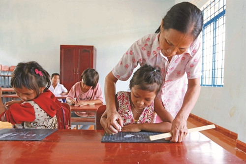 អ្នកគ្រូ លីធីអៀវ ណែនាំសិស្សថ្នាក់ទី ១ហាត់សរសេរអក្សរនៅចំណុចសាលាភូមិ