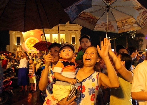 ប្រជាជនឈរហាលភ្លៀងមើលការបាញ់កាំជ្រួចនៅបឹង ហ៊ាន់គៀម រដ្ឋធានី ហាណូយ។ រូបថត៖ ទីភ្នាក់ងារព័ត៌មានវៀតណាម