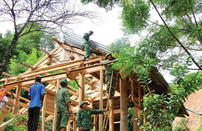 កម្មាភិបាល យុទ្ធជនកងទ័ពការពារព្រំដែនខេត្ត ងេអាន ជួយជ្រោមជ្រែងបងប្អូនជនជាតិនៅភូមិ ប៊ិញសឺន ១ ឃុំ តាកា ស្រុក គៃសឺន រើជញ្ជូនផ្ទះ ទ្រព្យសម្បត្តិចេញផុតពីតំបន់មានហានិភ័យ បំណាក់ដី bo-doi-4.jpg
