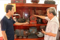 លោក កៅ តឹនហៀវ (ខាងស្តាំ) ឧទ្ទេសនាមវត្ថុបុរាណទាំងឡាយដែលលោកប្រមូលបាន