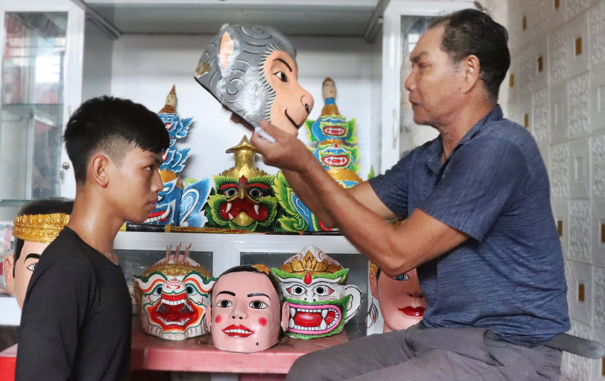 សិប្បករ ថាច់ ទុង ពាក់របាំងមុខហនុមានជូនសមាជិកក្រុមសម្តែងតួអង្គ។ b1-chhaydam.jpg