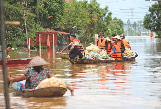 ក្រុមជំនួយសង្គ្រោះជាច្រើនបានផ្តល់ការឧបត្ថម្ភសម្ភារៈប្រើប្រាស់ដ៏ចាំបាច់ប្រចាំថ្ងៃដឹកជញ្ជូនចូលទៅជួយឧបត្ថម្ភប្រជាជននៅឃុំ ទ្រីអៀន ស្រុក អៀនយុង (ខេត្ត បាក់យ៉ាង) ត្រូវនៅដាច់ពីគេទាំងស្រុងដោយសារទំនប់ក្រោមត្រូវទឹកហូរហៀរលិច 6-Bac Giang-danh lam.jpg