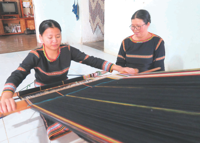 ប្អូន រើ ម៉ាញ់មិញធឺ កូនស្រីរបស់សិប្បការិនី អ៊ីធុយ ត្រូវបានម្ដាយបង្ហាត់បង្រៀនរបរត្បាញសំពត់សង្កិម 1-bahnar-du toan-kon tum.jpg