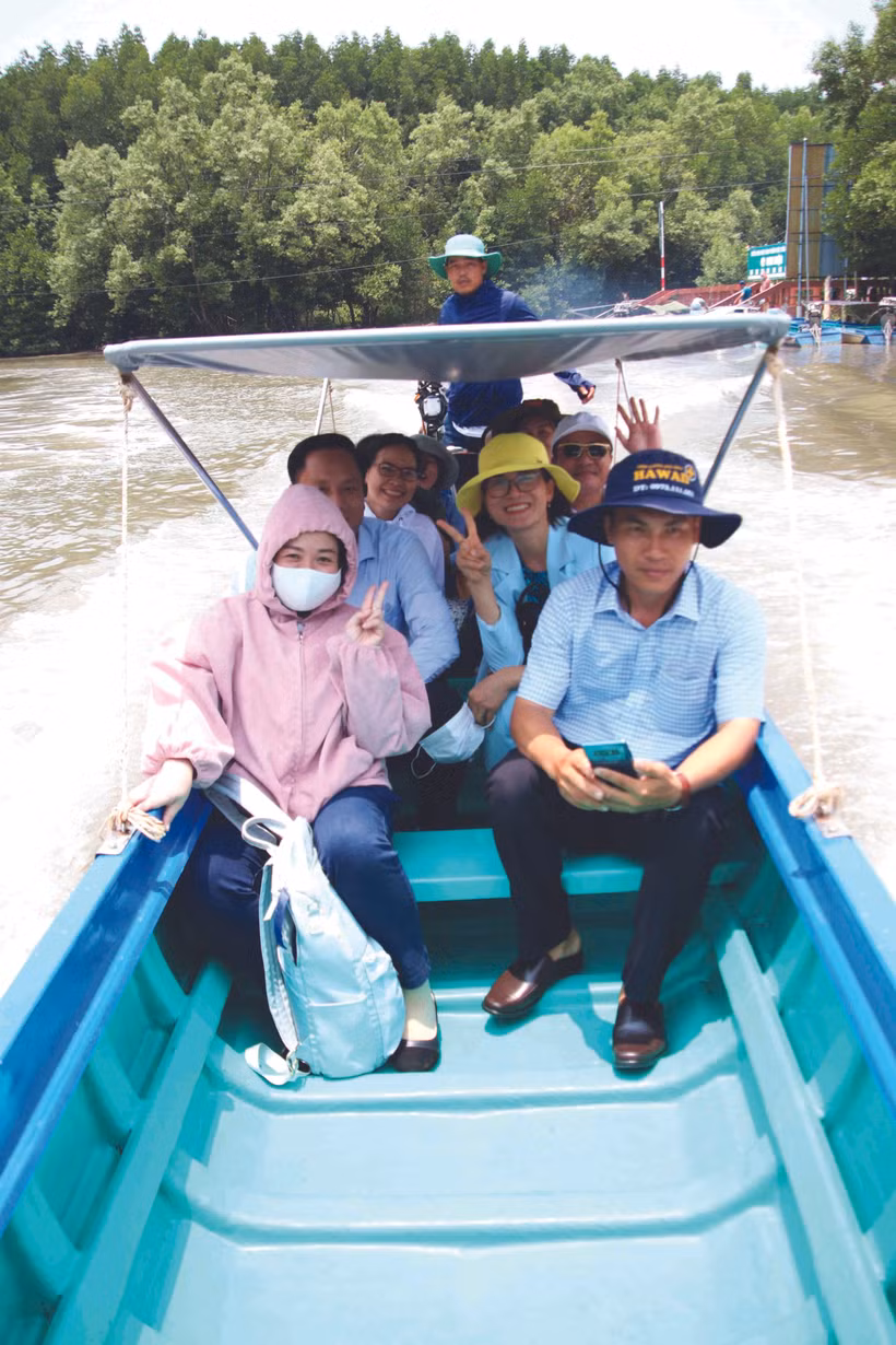 ភ្ញៀវទេសចរធ្វើដំណើរដោយទូកកាណូជ្រែកវែកបត់បែនចូលក្រោមម្លប់ព្រៃឈើកោងកាងដ៏ក្រាស់ក្រៃនៅក្នុងឃុំ ដឹតមូយ ស្រុក ង៉ុកហៀន